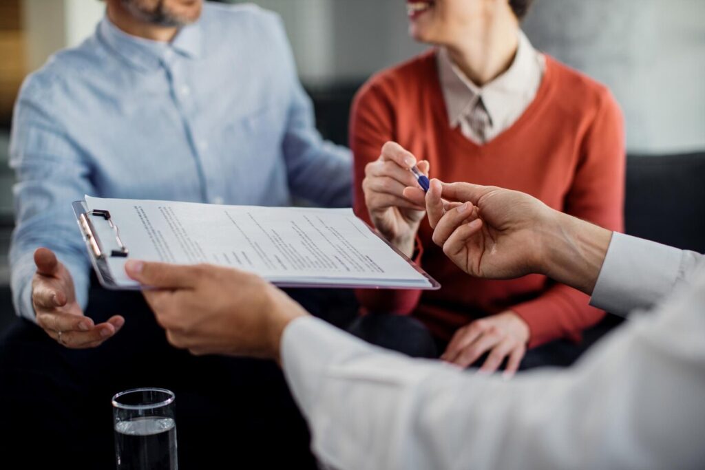 closeup de casal irreconhecivel assinando um contrato com consultor financeiro 637285 11092